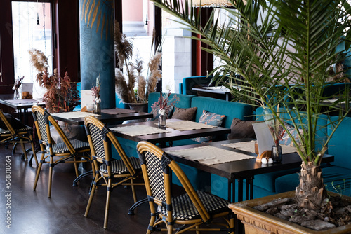 beautiful interior of the restaurant in blue tones. Tables and wicker chairs.