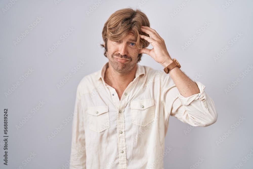 Middle age man standing over isolated background worried and stressed about a problem with hand on forehead, nervous and anxious for crisis Middle age man standing over isolated background worried and stressed about a problem with hand on forehead, nervous and anxious for crisis