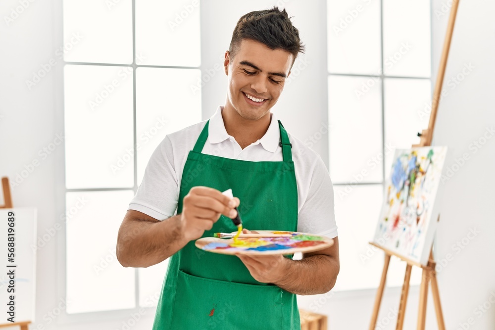 Young hispanic man smiling confident mixing color at art studio Young hispanic man smiling confident mixing color at art studio