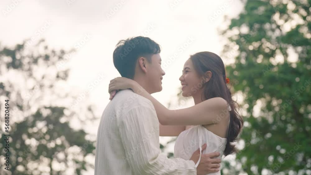 Sweet lovers arm around shoulder hug neck face to face talking at outdoor nature. Trust true love smile happy asia people in casual bride groom white dress begin family life just married young couples Sweet lovers arm around shoulder hug neck face to face talking at outdoor nature. Trust true love smile happy asia people in casual bride groom white dress begin family life just married young couples