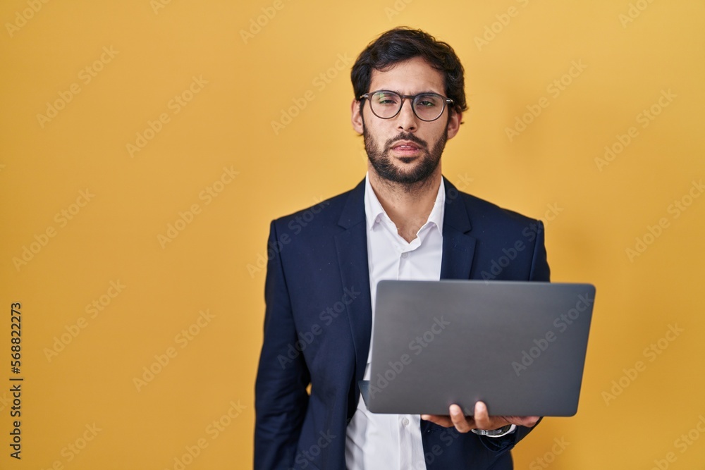 Handsome latin man working using computer laptop looking sleepy and tired, exhausted for fatigue and hangover, lazy eyes in the morning. Handsome latin man working using computer laptop looking sleepy and tired, exhausted for fatigue and hangover, lazy eyes in the morning.