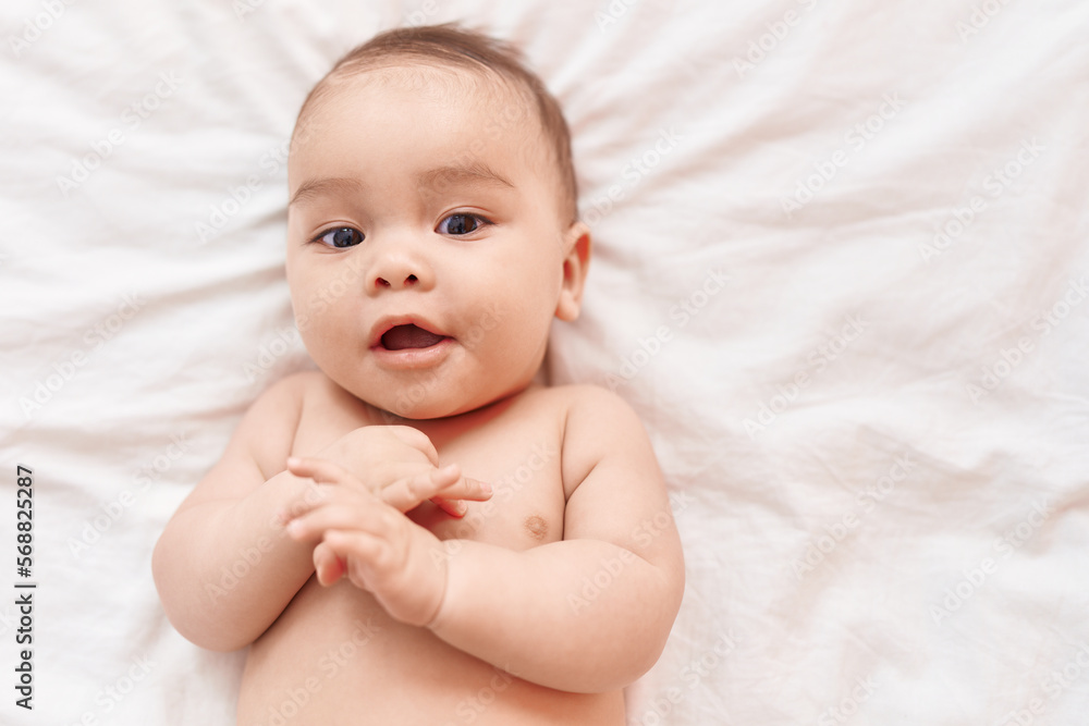Adorable hispanic toddler smiling confident lying on bed at bedroom Adorable hispanic toddler smiling confident lying on bed at bedroom