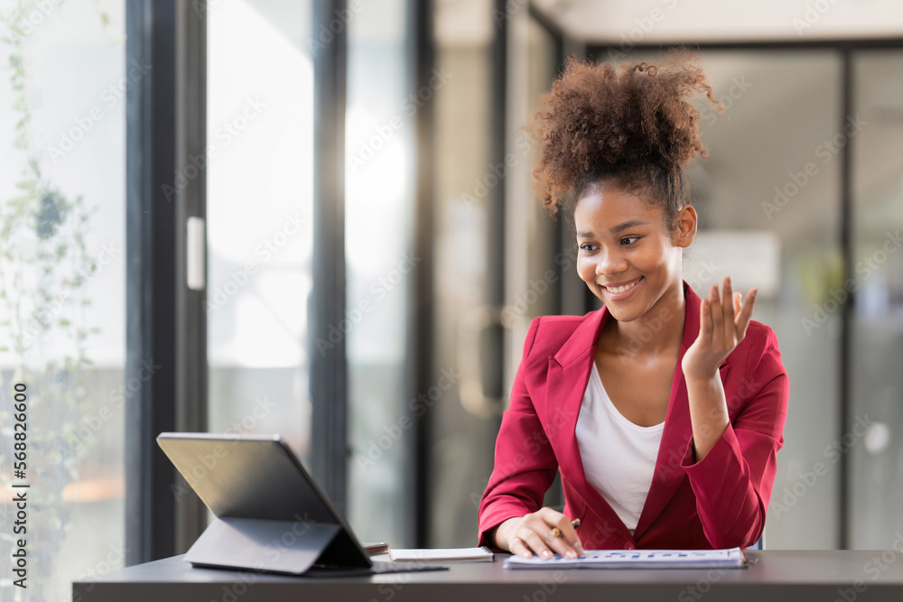 Female office worker working on a laptop in an office Female office worker working on a laptop in an office