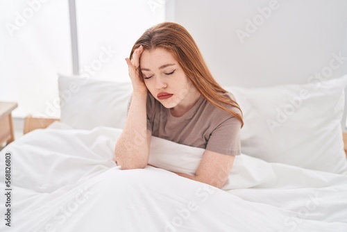 Young redhead woman stressed sitting on bed at bedroom © Krakenimages.com