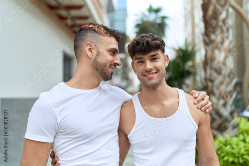 Two hispanic men couple smiling confident hugging each other at street