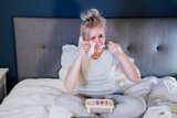Upset young woman holding tissue, eating ice cream from bucket while watching romantic movie on TV at home. Sad lady crying over breakup or relationship problems, feeling depressed and lonely