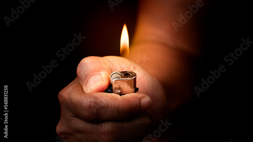 Cigarette lighter in hand isolated on black background.