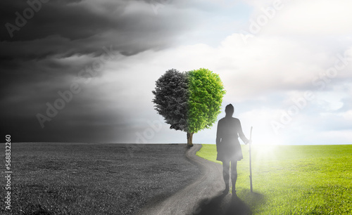 Silhouette einer Pilgerin auf einer Straße mit Baum in Herzform im Hintergrund