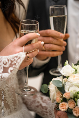 bride and groom holding wedding glasses with champagne