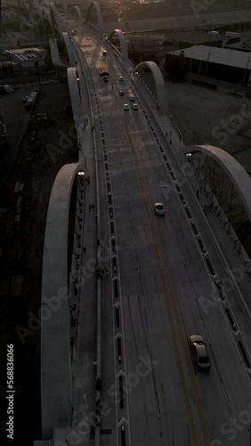 Aerial drone view of the 6th street bridge towards the downtown district in Los Angeles during the sunset