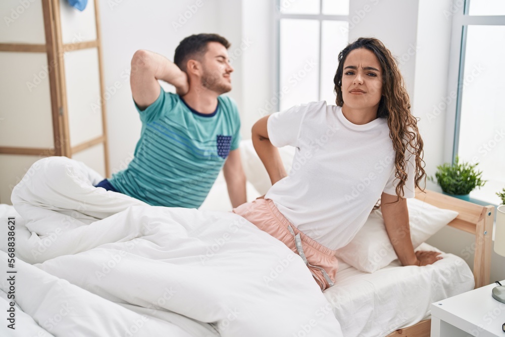 Young hispanic couple waking up with tired expression at bedroom Young hispanic couple waking up with tired expression at bedroom