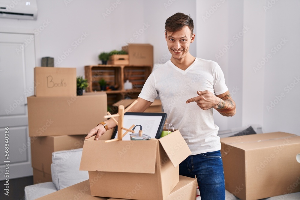 Caucasian man holding screwdriver at new home smiling happy pointing with hand and finger Caucasian man holding screwdriver at new home smiling happy pointing with hand and finger