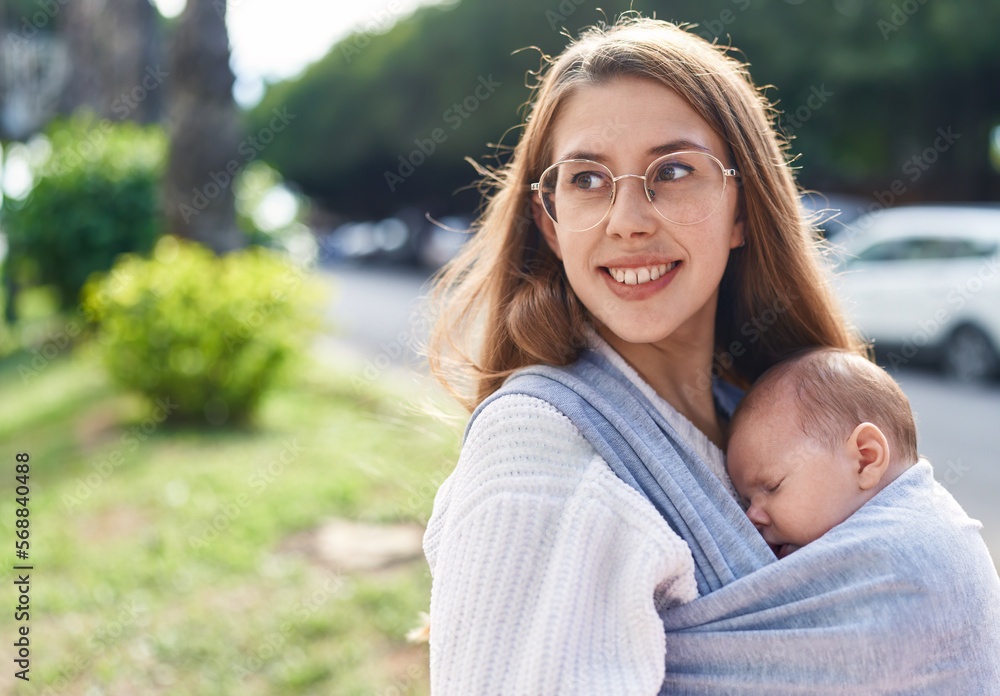 Naklejka premium Mother and son sleeping baby standing at street