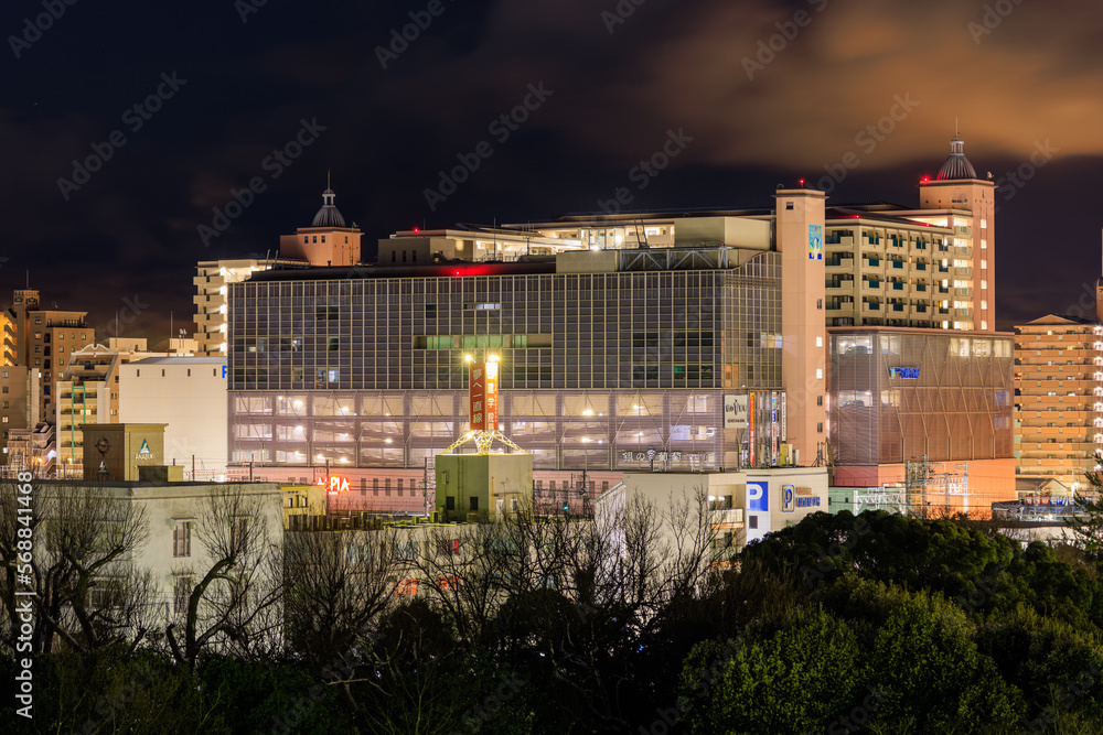 Akashi, Japan - January 25, 2023: Large shopping mall and apartment buildings in city center at night