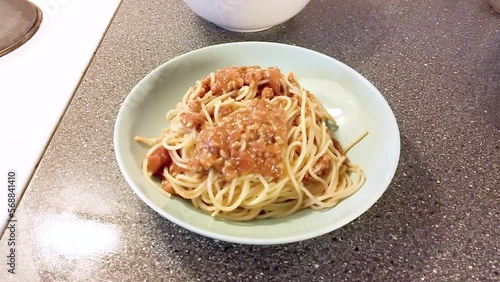 Plate with spaghetti bolognese on kitchen table - Cooking Spaghetti Bolognese photo