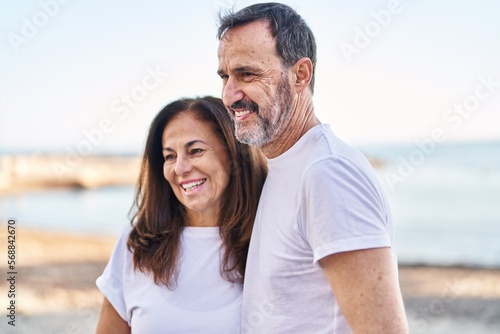 Middle age man and woman couple standing together at seaside