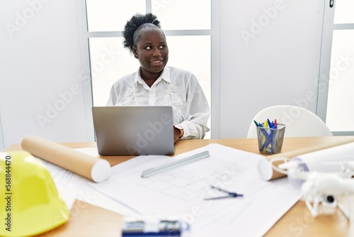 Young african american woman architect using laptop working at architecture studio