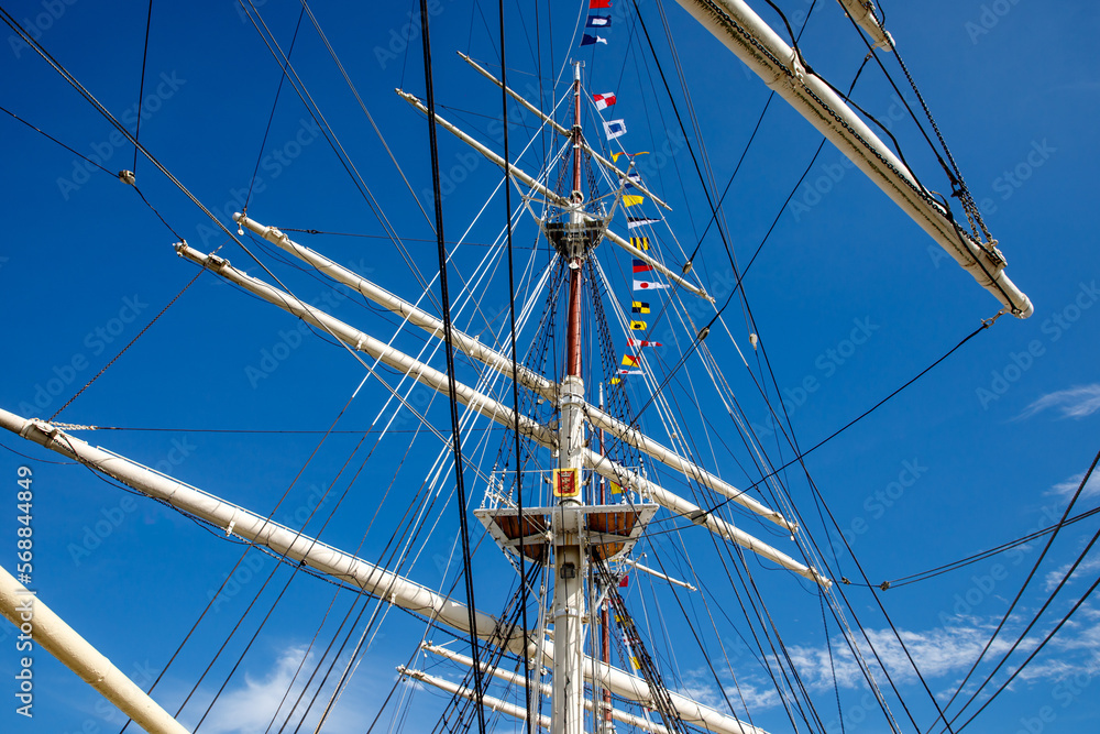 Sailing ship mast with rigging and cables against the sky. Sailing ship mast with rigging and cables against the sky.