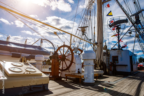 Sailship deck with helm, rigging and cables.