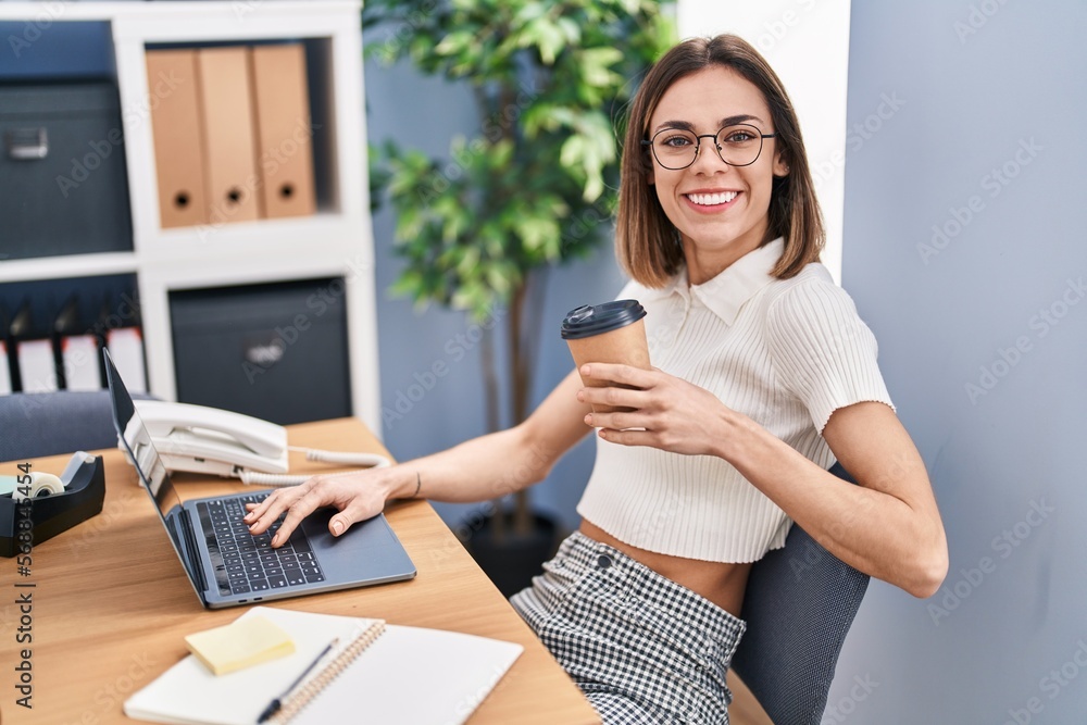 Young beautiful hispanic woman business worker using laptop drinking coffee at office Young beautiful hispanic woman business worker using laptop drinking coffee at office