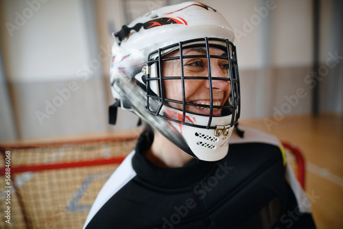 Photography Close-up of woman floorball goalkeeper in helmet concetrating on game in gym