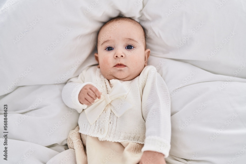 Adorable baby relaxed lying on bed at bedroom Adorable baby relaxed lying on bed at bedroom