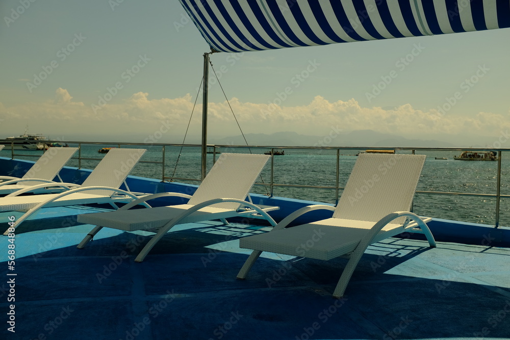 Sunbed on Boat with stripe blue tent and background of sea, sky and Clouds at Lembongan Island, Bali -Indonesia