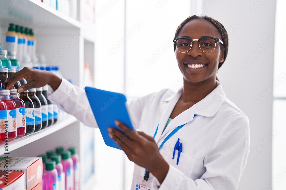 African american woman pharmacist using touchpad working at pharmacy African american woman pharmacist using touchpad working at pharmacy