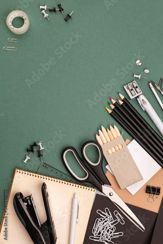 stationery items around of image on green background. Back to school background, banner with copy space. Student's or engineer's supplies. Office objects on dark green background. Calculator, keyboard