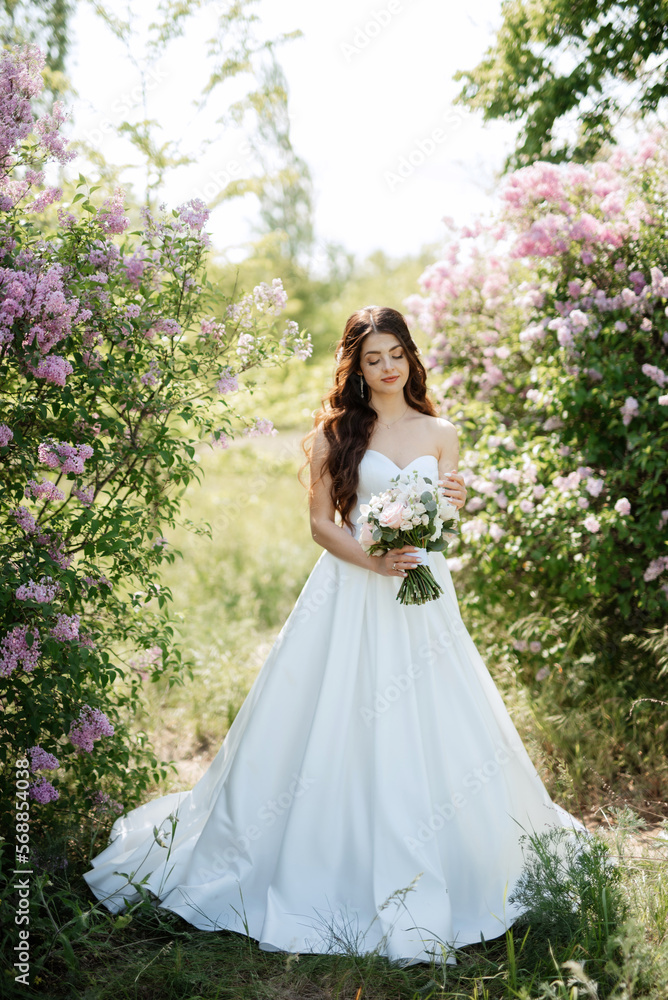 young girl bride in a white dress in a spring forest in lilac bushes young girl bride in a white dress in a spring forest in lilac bushes
