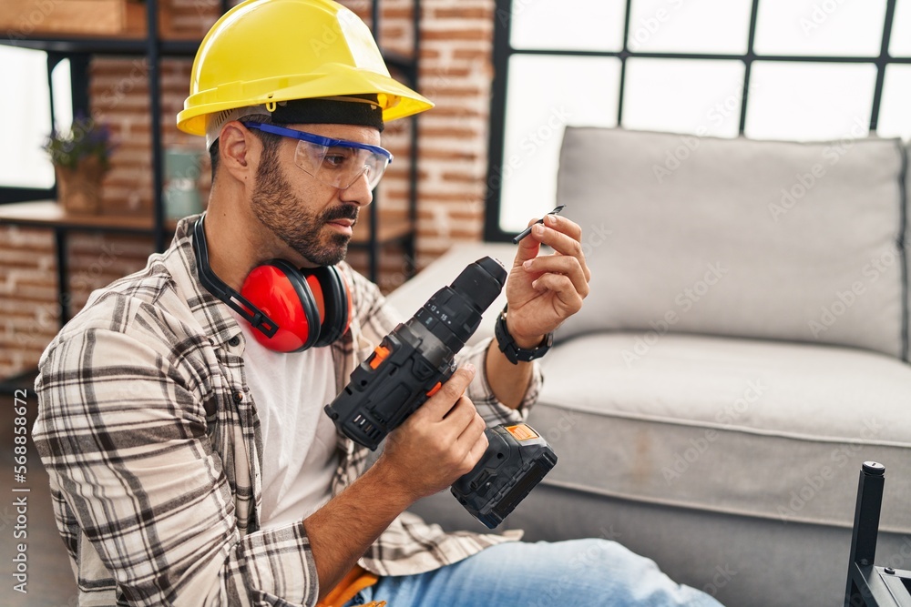 Young hispanic man worker smiling confident holding drill at home Young hispanic man worker smiling confident holding drill at home