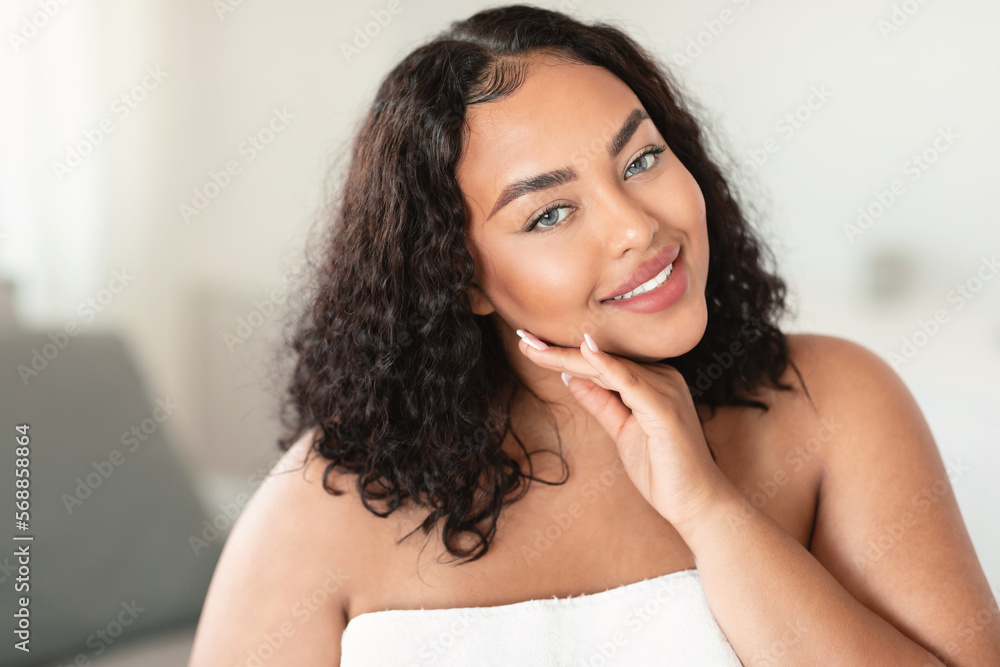 Portrait of beautiful plus size woman posing and touching her face, enjoying her smooth glow skin Portrait of beautiful plus size woman posing and touching her face, enjoying her smooth glow skin