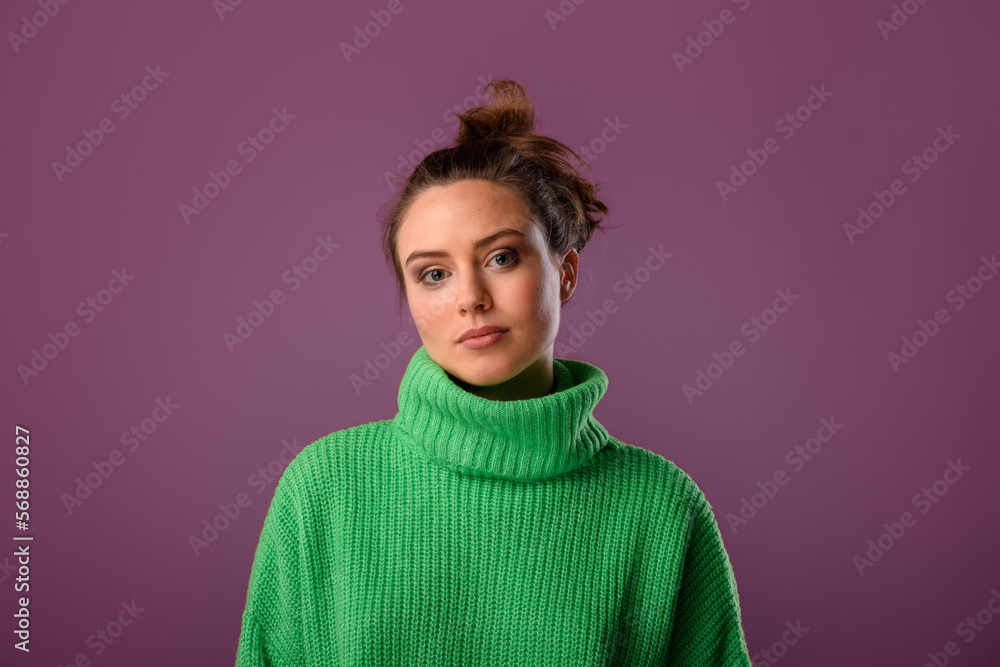 Young woman posing in sweater during studio shooting. Young woman posing in sweater during studio shooting.
