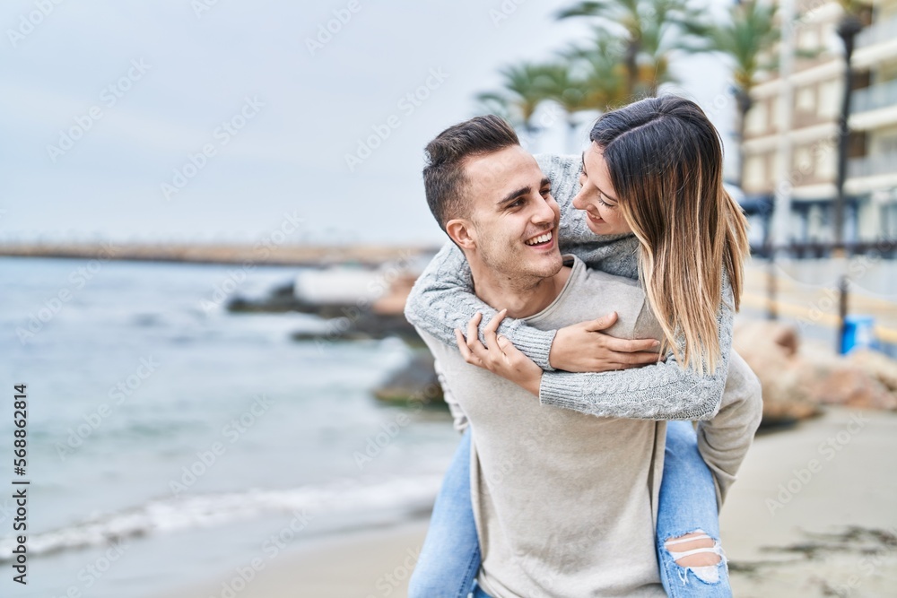 Man and woman couple hugging each other holding on back at seaside Man and woman couple hugging each other holding on back at seaside