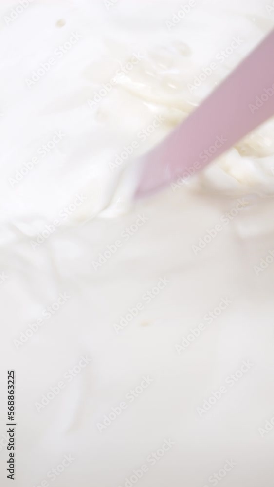 Vertical slow motion video, using a spatula to mix farm fresh milk, healthy milk drink concept. Vertical slow motion video, using a spatula to mix farm fresh milk, healthy milk drink concept.