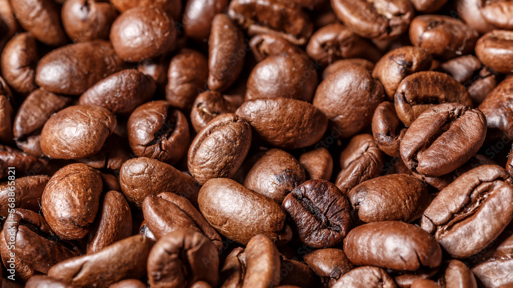 Fototapeta premium Freshly roasted coffee beans background.Dark roasted coffee beans with scoop on wooden background.