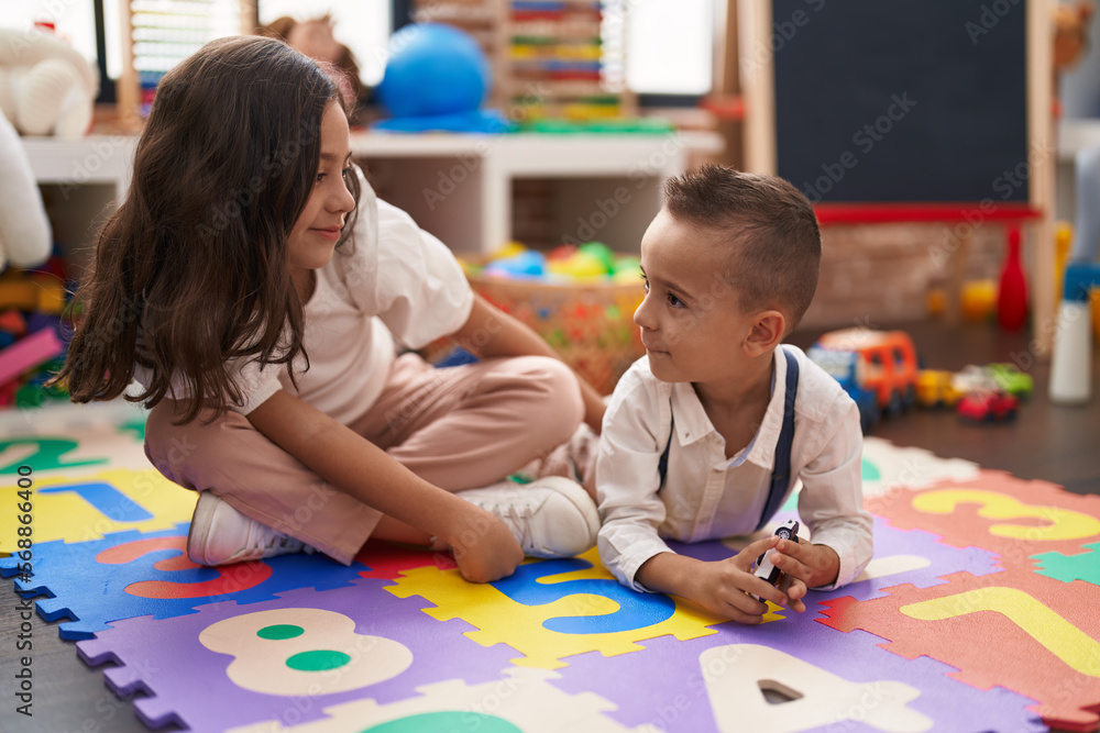 Fototapeta premium Brother and sister smiling confident sitting on floor at kindergarten