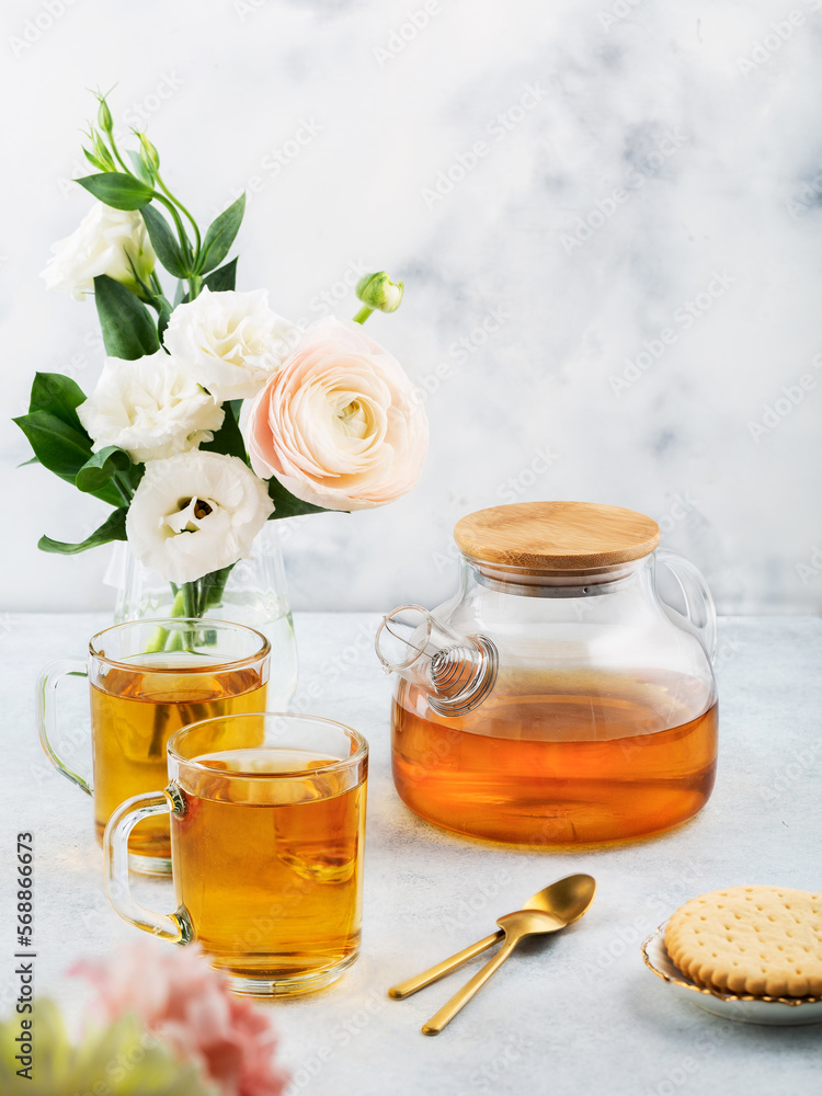 Green tea in a glass teapot and cups. On a white background. Tea concept.
