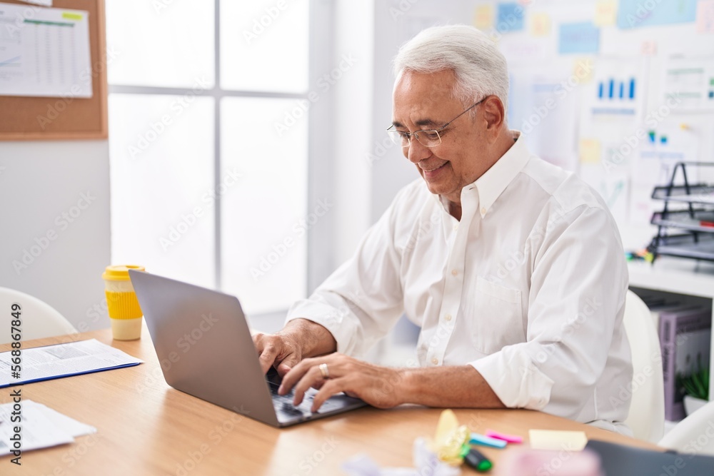 Middle age grey-haired man business worker using laptop working at office Middle age grey-haired man business worker using laptop working at office