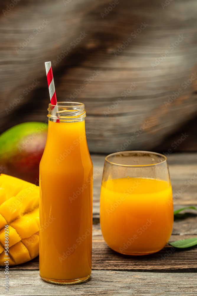 Fototapeta premium Fresh tropical fruit smoothie mango juice in a glass jar with a tube. place for text