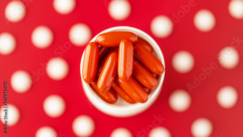 ubiquinol (coQ10) coenzyme q10 dietary supplement pills softgels top view closeup on red background. immune prevention care concept photo