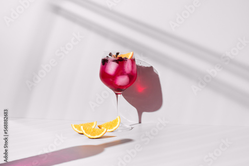 Refrescante ginebra rosa con tónica adornado con naranja sobre un fondo con sombras