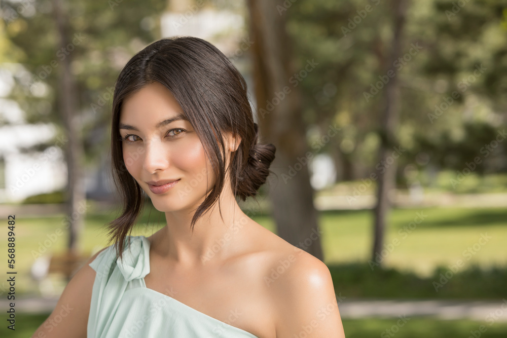 Portrait of beautiful woman looking at camera in park Portrait of beautiful woman looking at camera in park