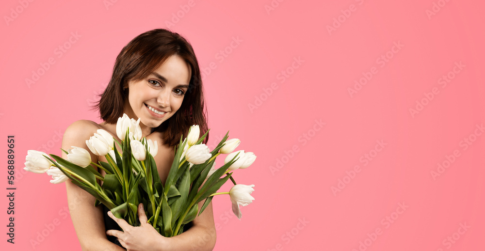 Smiling pretty young european naked woman hug bouquet of flowers, enjoy tenderness, fresh
