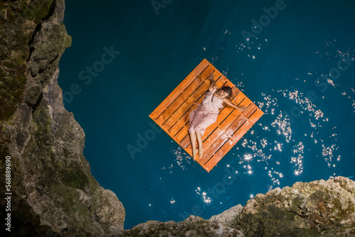 Aerial view of woman lying on wooden raft photo