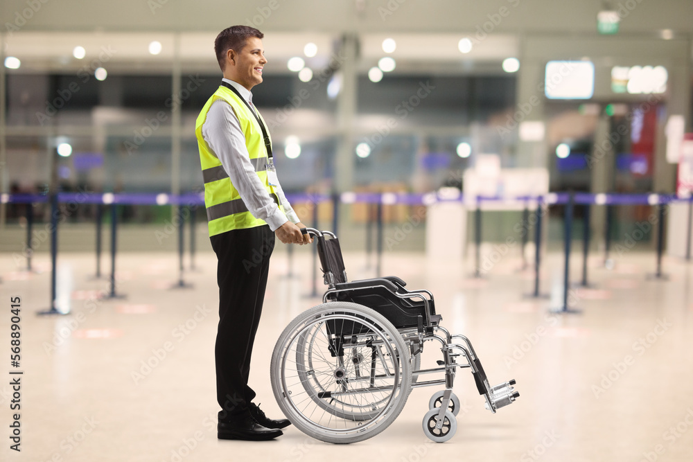 Obraz premium Male assitance worker at the airport with a wheelchair