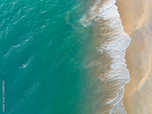 Beach top view of soft blue ocean wave on clean sandy beach and relaxing aerial scene, summer vacation holiday template banner. Waves surf with blue ocean lagoon 