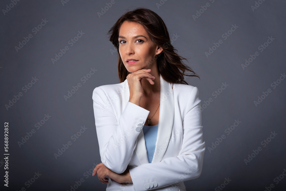 Close-up of an attractive woman smiling against at grey background Close-up of an attractive woman smiling against at grey background