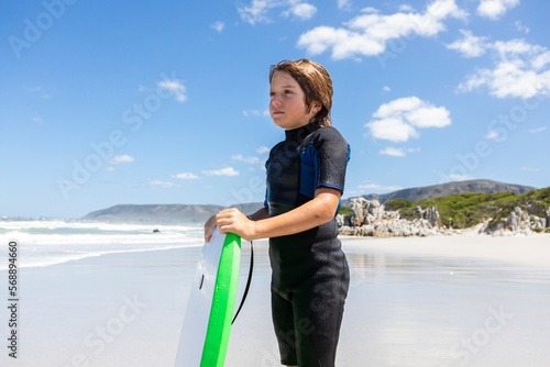 Boy (10-11) with bodyboard on Grotto Beach