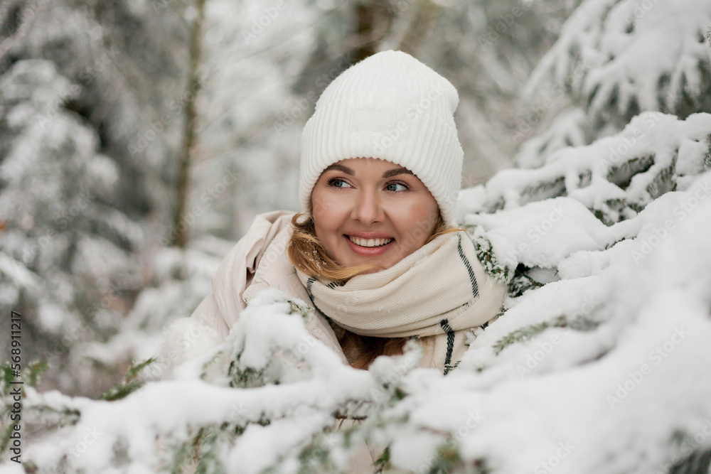 Beautiful young woman in light warm cozy clothes walks in snowy forest. Stylish model with beautiful smile. Winter vacation. Beautiful young woman in light warm cozy clothes walks in snowy forest. Stylish model with beautiful smile. Winter vacation.